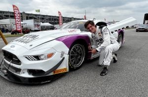 Matt Brabham poses with the no.20 GYM WEED CD Racing Ford Mustang at Indianapolis Motor Speedway